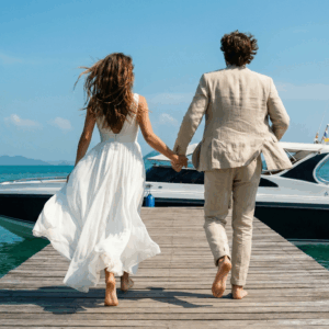 Newlyweds running towards a speedboat to start their honeymoon in Phuket.